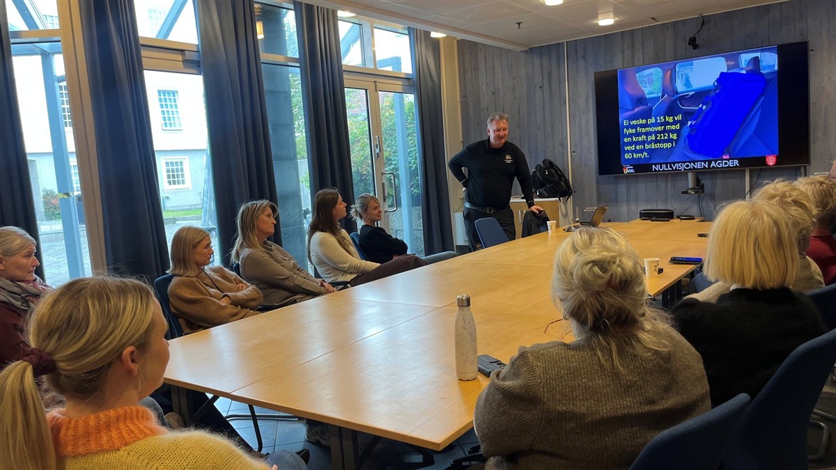 Mann viser livsviktig informasjon om sikkerhet i trafikken på skjermen foran flere ansatte som følger nøye med. - Klikk for stort bilde