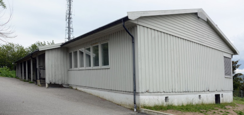 Fotografi av byen Farsund tatt fra Farøy. Havnebassenget er i forgrunnen med byen i bakgrunnen. Kirkebakken ligger i midten av bildet, og man kan se den gamle skolen - Klikk for stort bilde